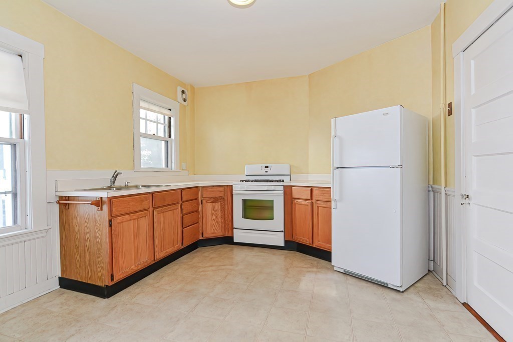 17-19 Walnut Road Somerville, MA 02145 - Photo 8 of 42 a kitchen with stainless steel appliances a refrigerator sink and white cabinets