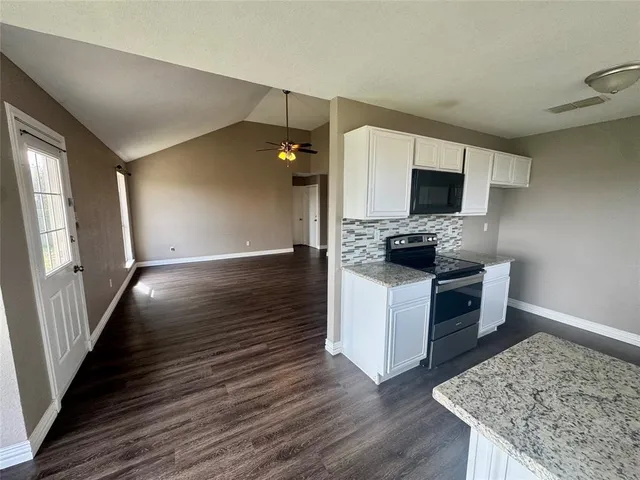 a kitchen with sink cabinets and wooden floor