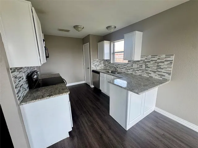 a kitchen with stainless steel appliances granite countertop a sink stove and cabinets
