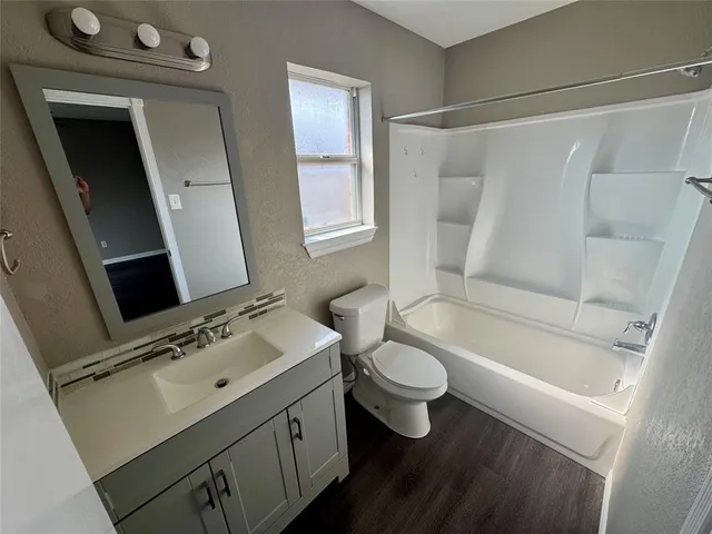 a bathroom with a sink vanity granite tub and a mirror