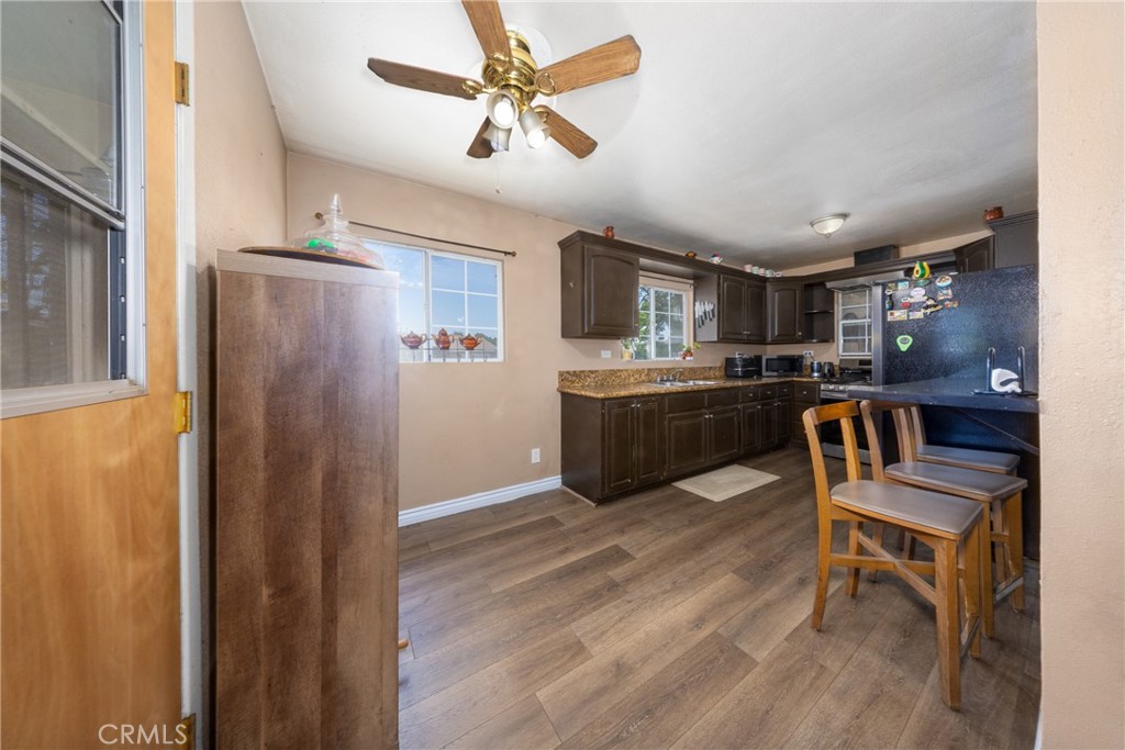 566 South Sage Avenue Rialto, CA 92376 - Photo 13 of 28 a kitchen with stainless steel appliances kitchen island granite countertop a refrigerator a stove a sink a dining table and chairs with wooden floor