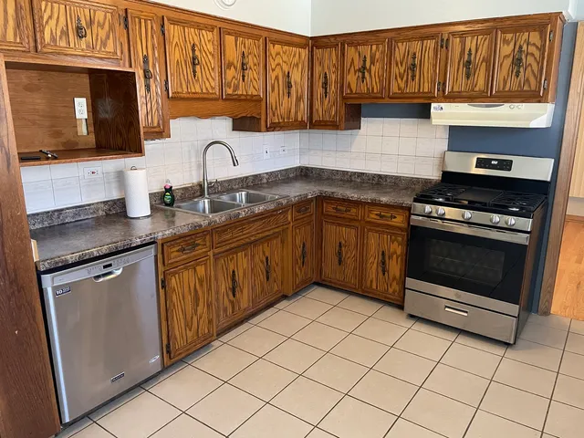 a kitchen with granite countertop a stove top oven microwave and cabinets