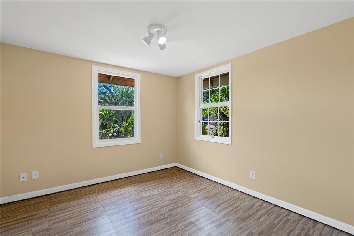 752 Noholani Street Haiku, HI 96708 - Photo 28 of 45 an empty room with wooden floor and windows