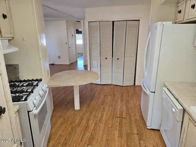 a kitchen with wooden floor and electronic appliances