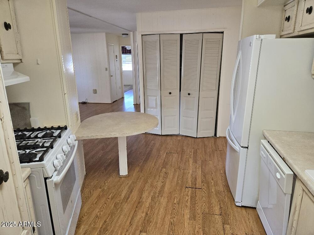 19065 North Dinero Road Sun City, AZ 85373 - Photo 15 of 37 a kitchen with wooden floor and electronic appliances