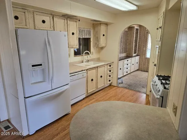 a kitchen with stainless steel appliances a refrigerator sink and cabinets