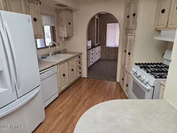 a kitchen with stainless steel appliances a refrigerator stove and wooden floor