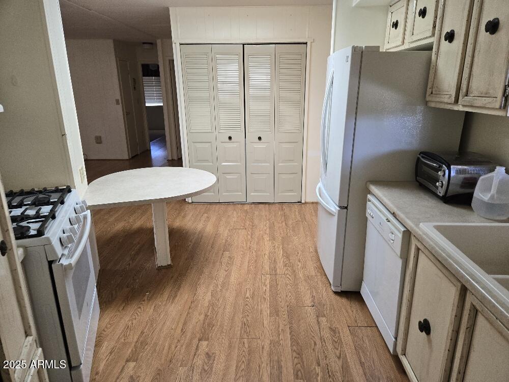 19065 North Dinero Road Sun City, AZ 85373 - Photo 24 of 37 a kitchen with stainless steel appliances a refrigerator stove and wooden floor