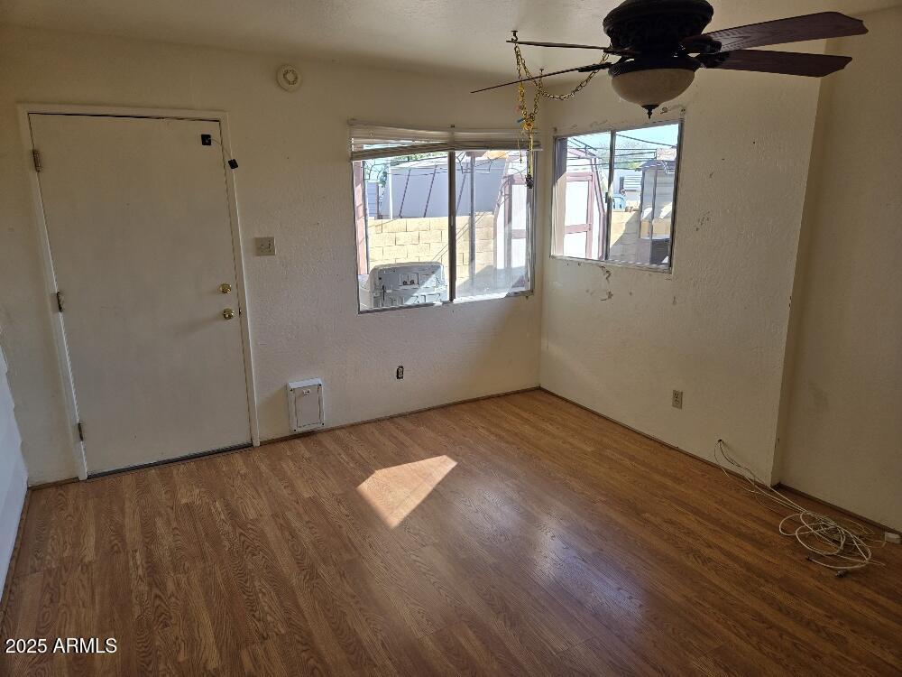 19065 North Dinero Road Sun City, AZ 85373 - Photo 33 of 37 an empty room with wooden floor and windows