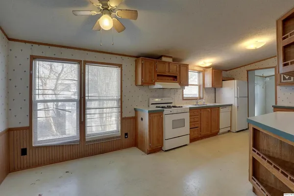an empty room with windows and fan