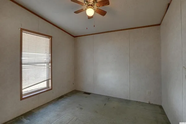 en empty room with windows and fan
