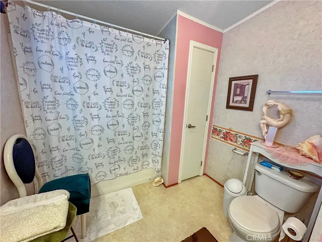 a bathroom with a toilet and a shower curtain
