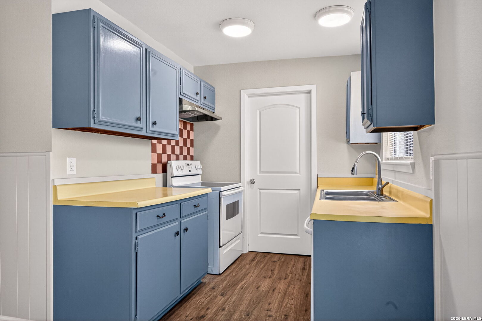 301 Deborah Drive Converse, TX 78109 - Photo 11 of 27 a kitchen with a sink a stove cabinets and wooden floor