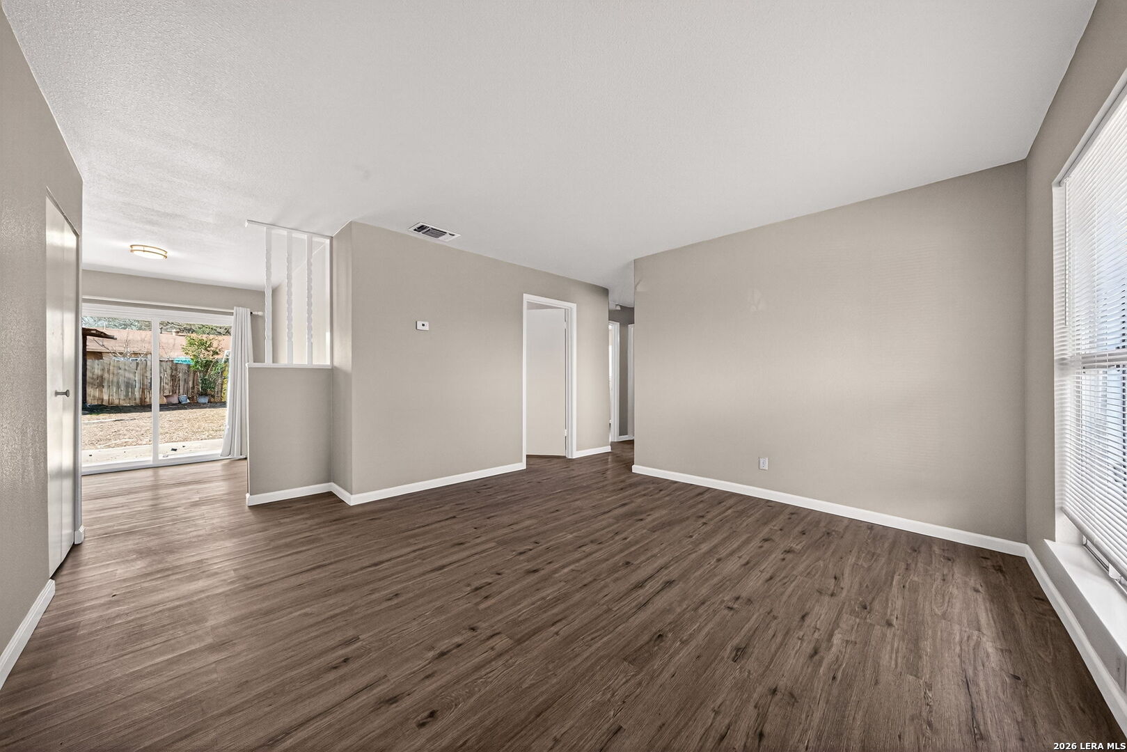 301 Deborah Drive Converse, TX 78109 - Photo 7 of 27 a view of an empty room with wooden floor and a window