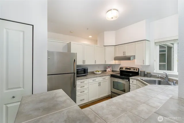 a kitchen with stainless steel appliances a stove a sink and a refrigerator
