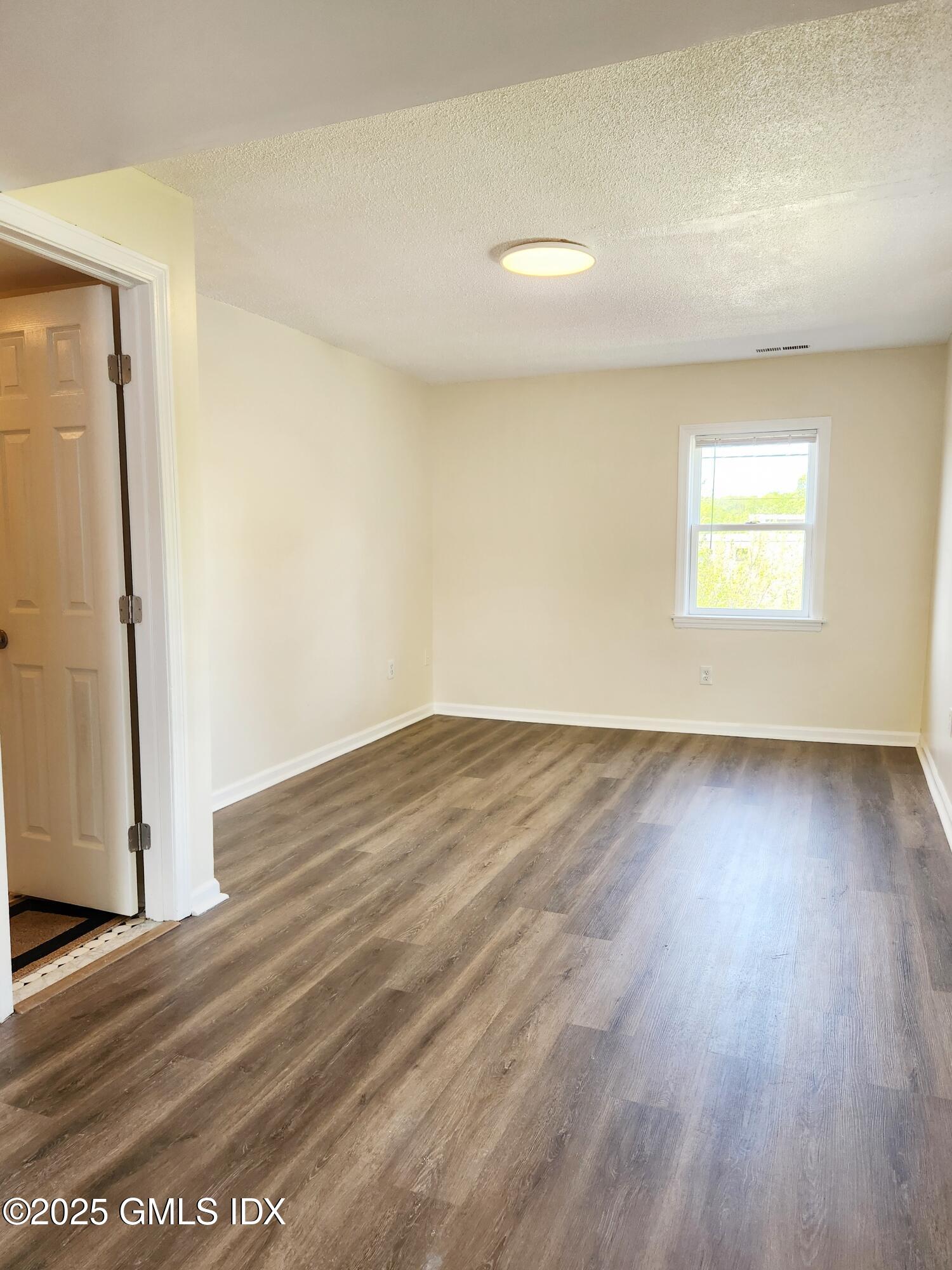336 Hamilton Avenue, Unit B Greenwich, CT 06830 - Photo 3 of 16 an empty room with wooden floor and a window