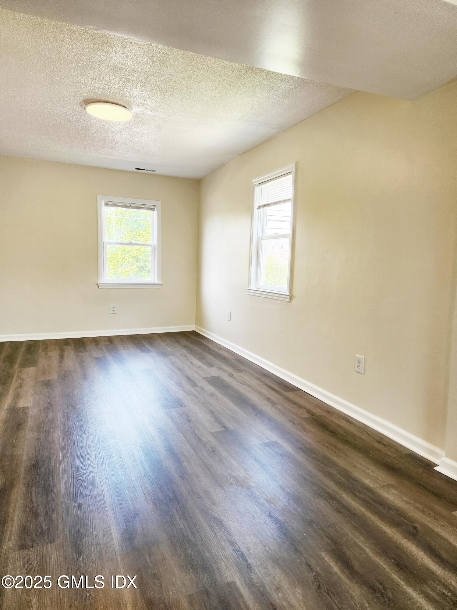 336 Hamilton Avenue, Unit B Greenwich, CT 06830 - Photo 4 of 16 an empty room with wooden floor and windows