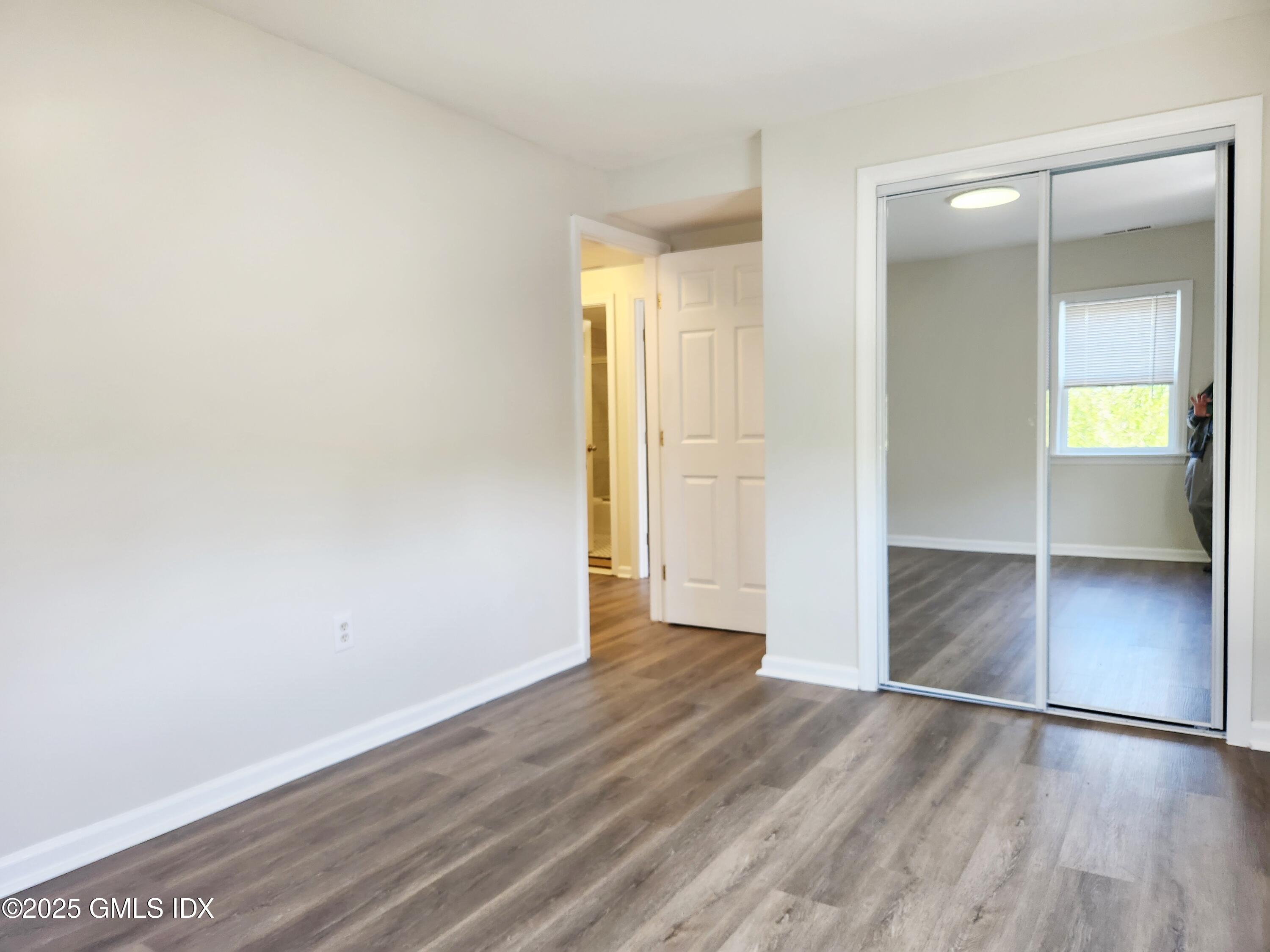 336 Hamilton Avenue, Unit B Greenwich, CT 06830 - Photo 7 of 16 an empty room with wooden floor closet and windows