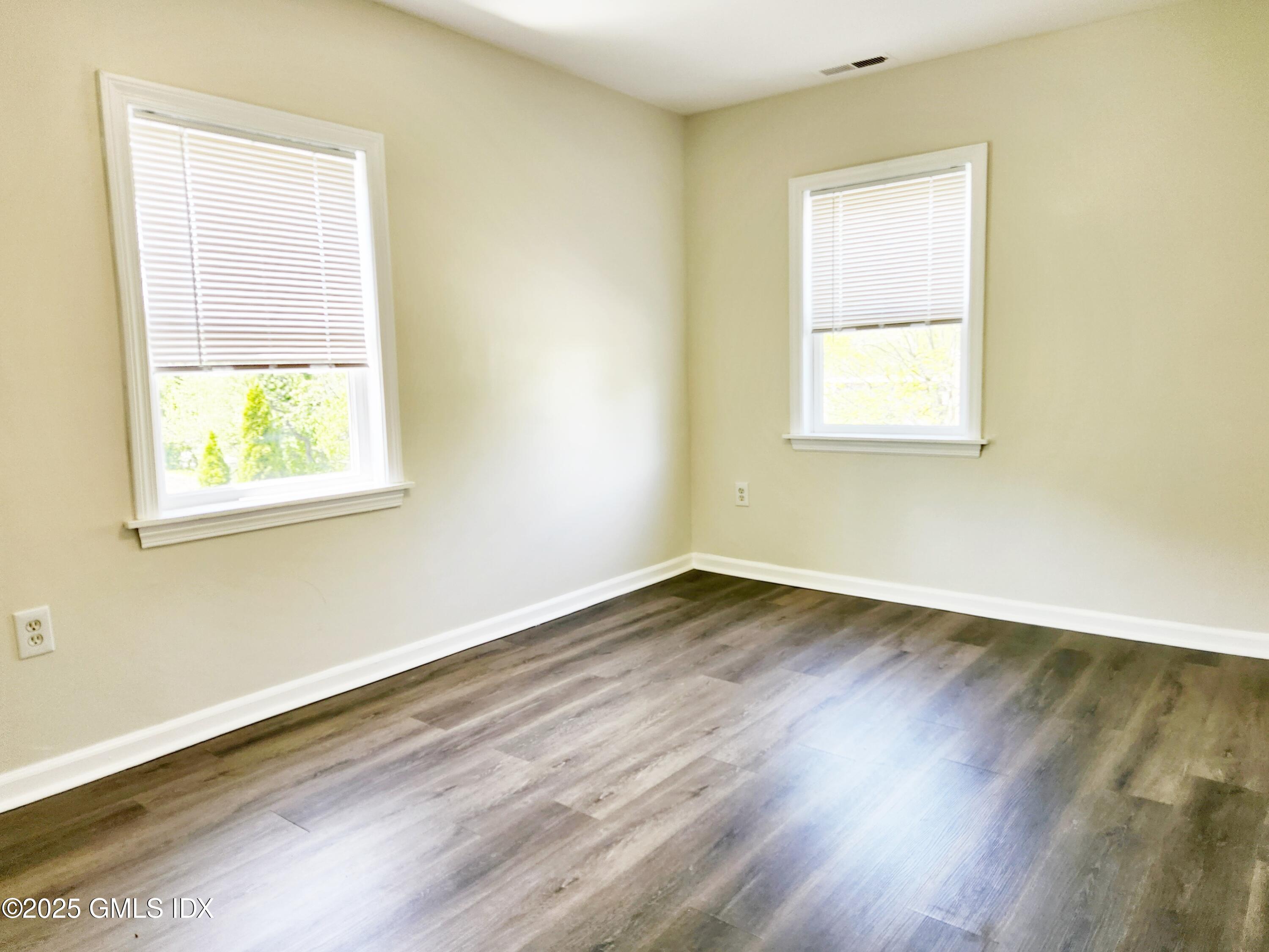 336 Hamilton Avenue, Unit B Greenwich, CT 06830 - Photo 8 of 16 a view of an empty room with wooden floor and a window