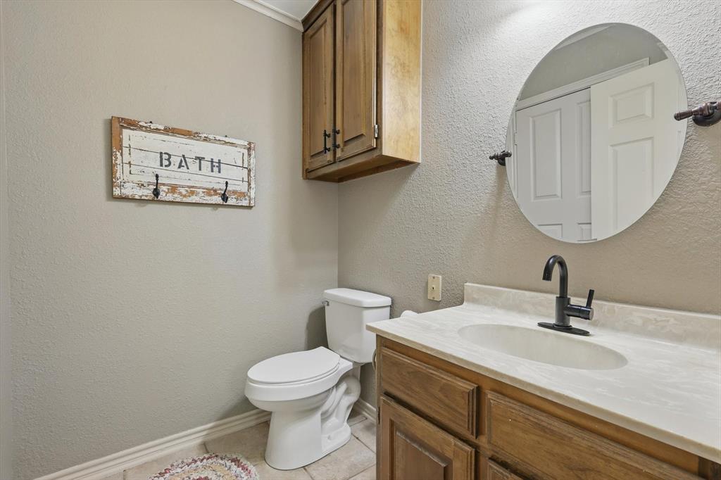 1904 Oak Ridge Trail Bridgeport, TX 76426 - Photo 29 of 40 a bathroom with a toilet a sink and mirror
