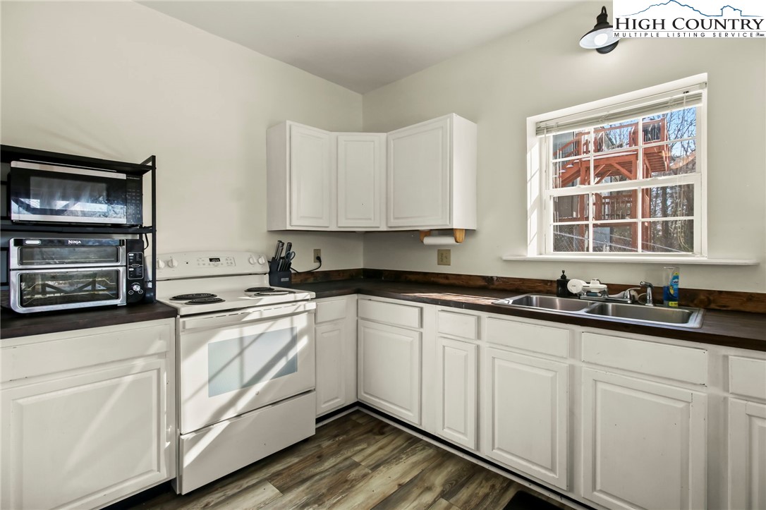 282 Charles Street Boone, NC 28607 - Photo 31 of 47 a kitchen with stainless steel appliances granite countertop a stove a sink and white cabinets