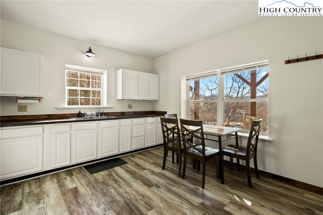 282 Charles Street Boone, NC 28607 - Photo 32 of 47 a kitchen with granite countertop white cabinets dining table and chairs