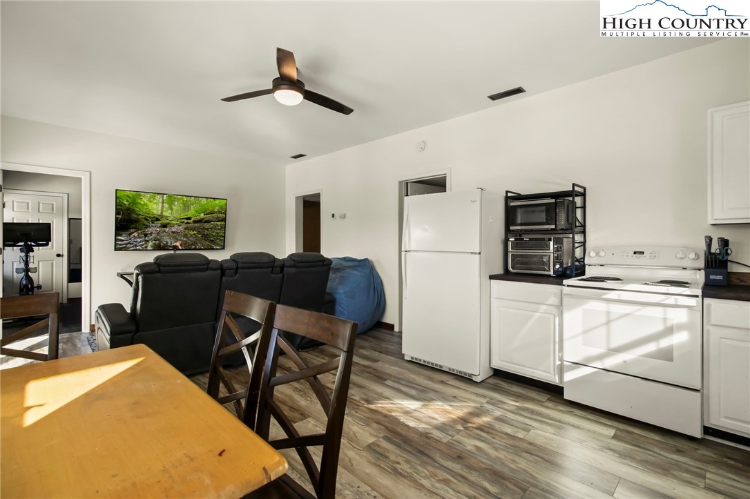 282 Charles Street Boone, NC 28607 - Photo 33 of 47 a kitchen with stainless steel appliances kitchen island granite countertop a refrigerator a stove a microwave oven a dining table and chairs with wooden floor