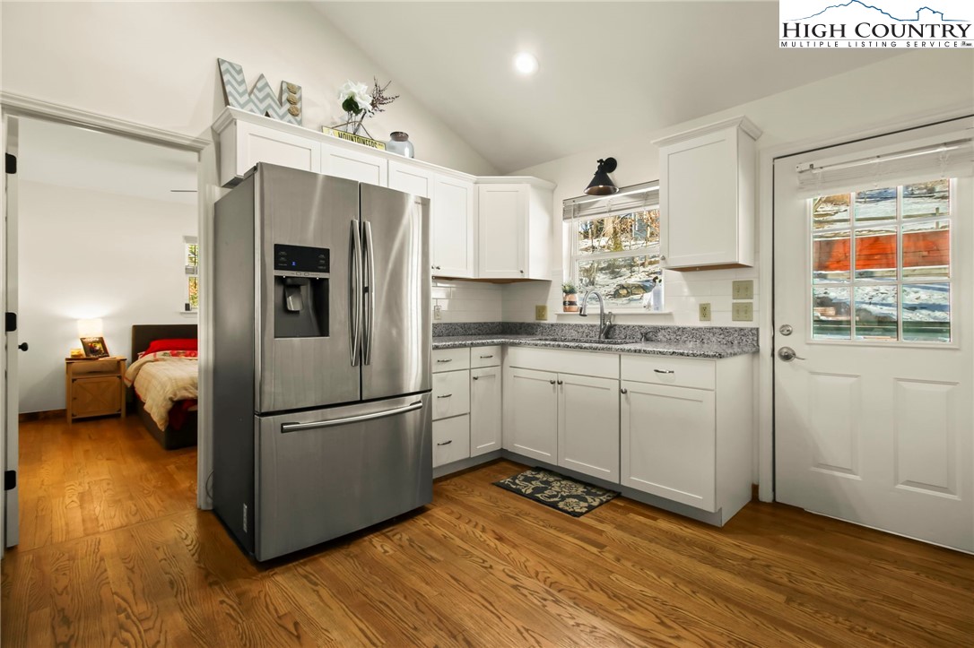 282 Charles Street Boone, NC 28607 - Photo 4 of 47 a kitchen with kitchen island white cabinets and white appliances