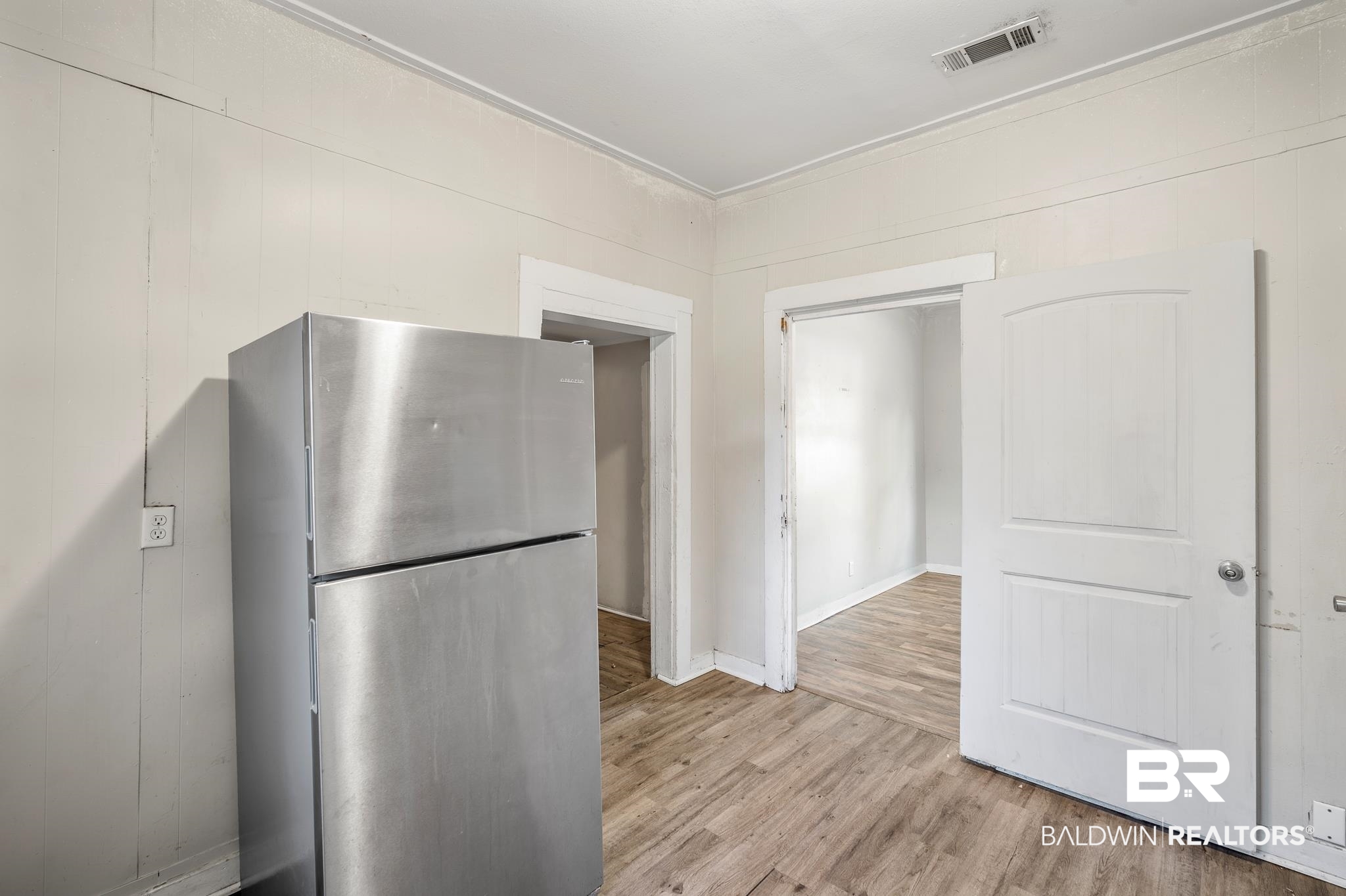 401 Gaston Street Mobile, AL 36603 - Photo 13 of 17 Kitchen with wooden walls, stainless steel fridge, and light wood-type flooring