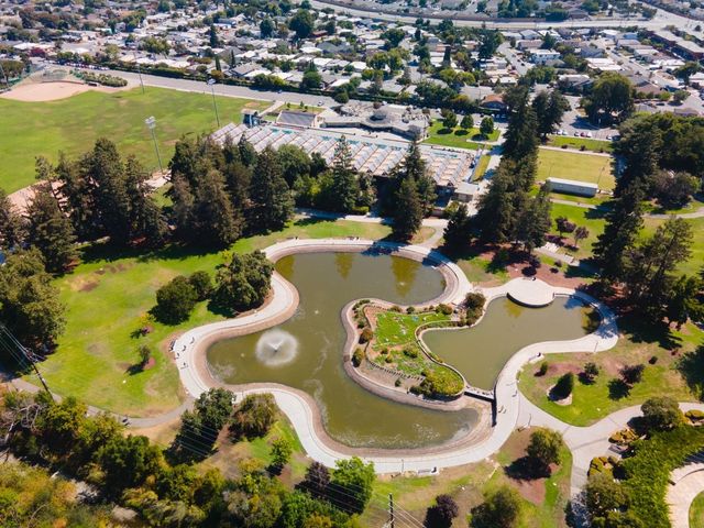 an aerial view of a house with a swimming pool yard and lake view in back