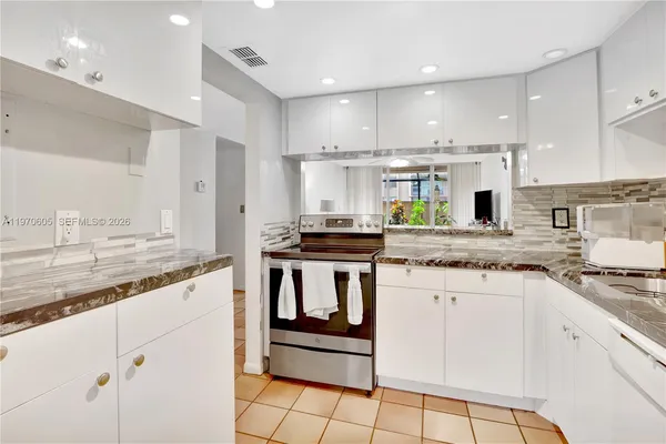 a kitchen with stainless steel appliances granite countertop a stove a sink and a refrigerator
