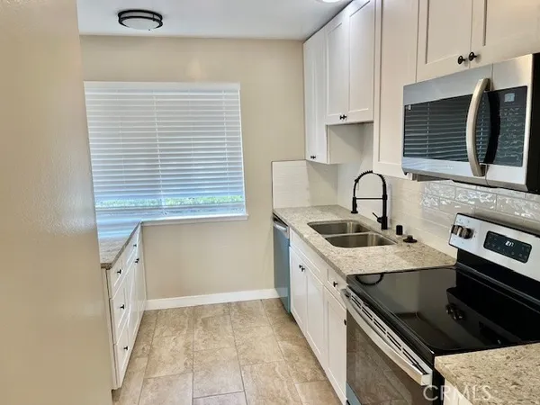 a kitchen with a sink stove and cabinets