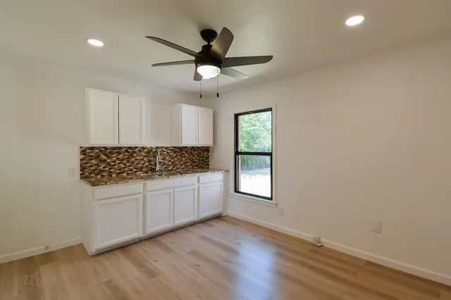 a kitchen with a refrigerator and countertop white cabinets