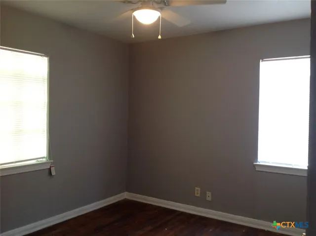 a view of a small space with wooden floor and a window