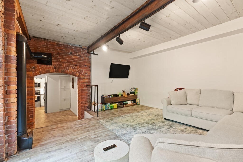 50 Rantoul Street, Unit 110 Beverly, MA 01915 - Photo 11 of 37 a living room with furniture and a flat screen tv