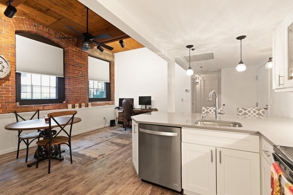 50 Rantoul Street, Unit 110 Beverly, MA 01915 - Photo 13 of 37 a kitchen with sink cabinets and wooden floor