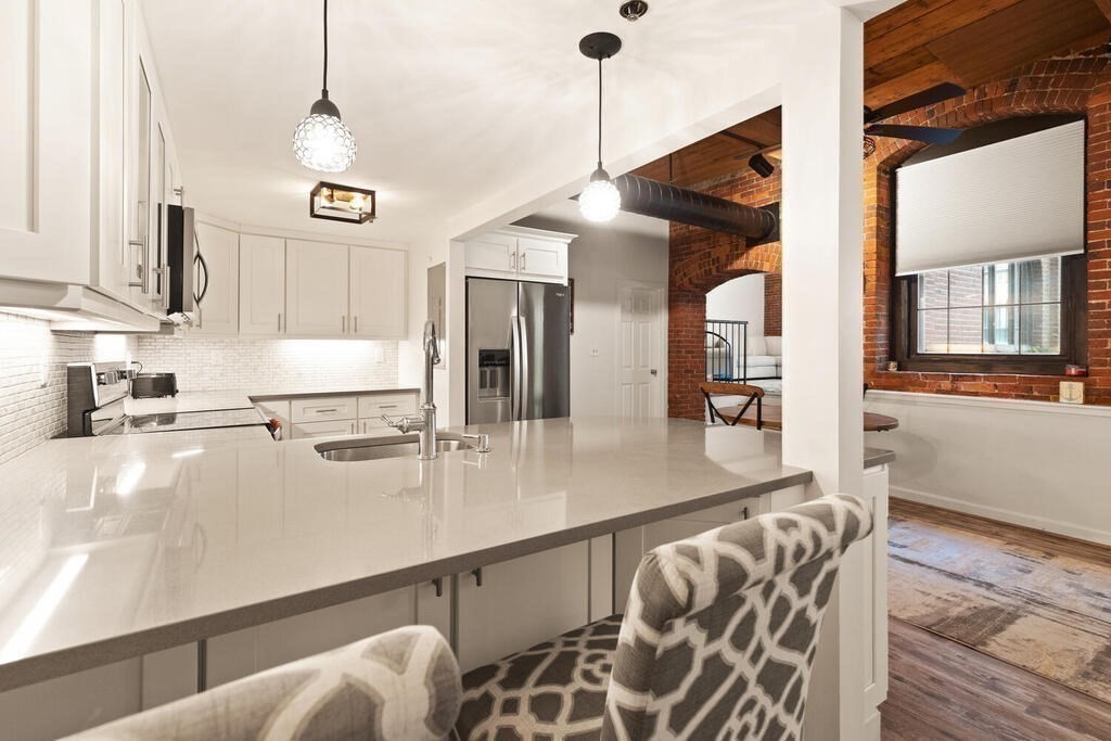 50 Rantoul Street, Unit 110 Beverly, MA 01915 - Photo 15 of 37 a kitchen with stainless steel appliances granite countertop a sink a oven and a counter space