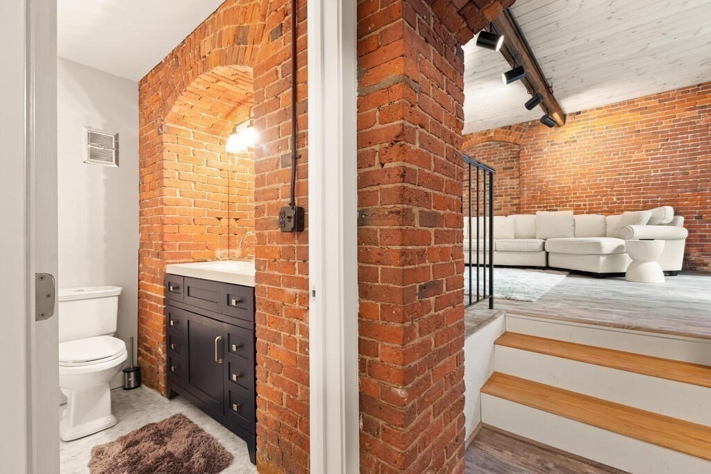 50 Rantoul Street, Unit 110 Beverly, MA 01915 - Photo 19 of 37 a en suite bathroom with a granite countertop sink and a mirror