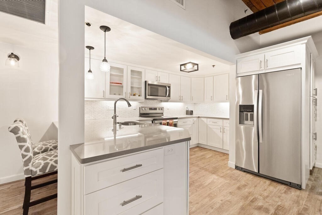 50 Rantoul Street, Unit 110 Beverly, MA 01915 - Photo 20 of 37 a kitchen with stainless steel appliances granite countertop a refrigerator and a sink