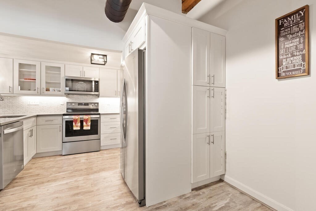 50 Rantoul Street, Unit 110 Beverly, MA 01915 - Photo 21 of 37 a kitchen with stainless steel appliances granite countertop a refrigerator and a stove top oven