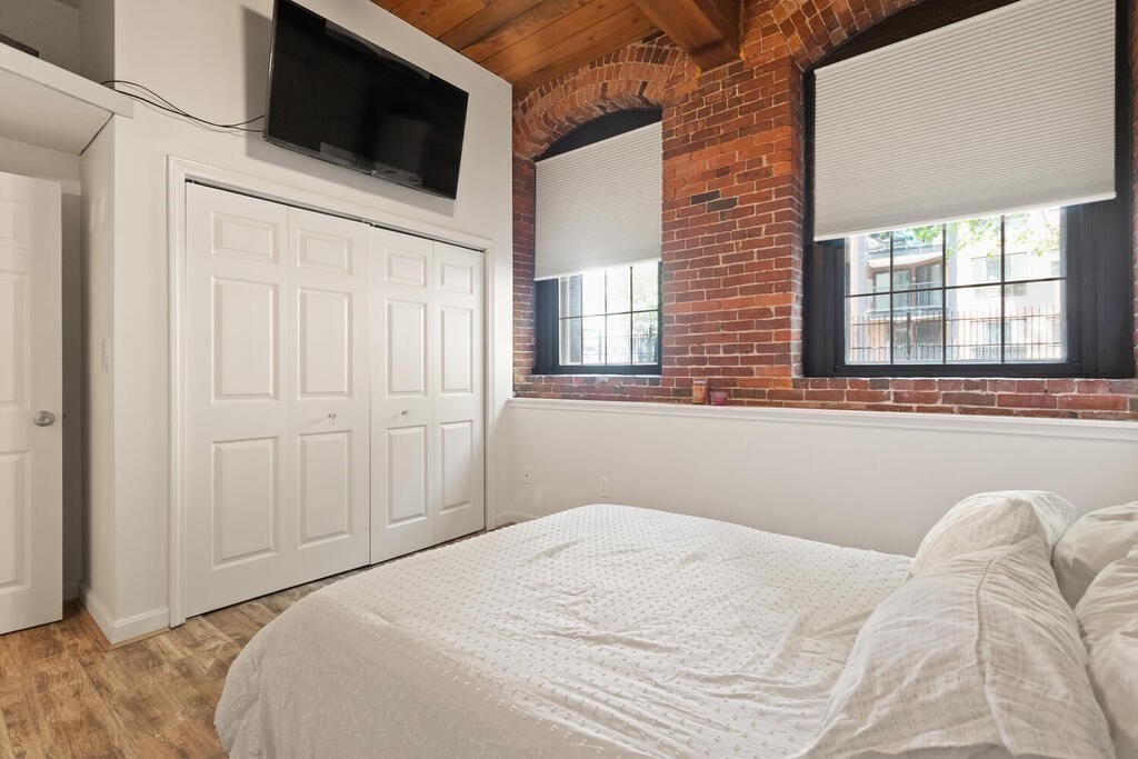 50 Rantoul Street, Unit 110 Beverly, MA 01915 - Photo 23 of 37 a bedroom with a bed a flat screen tv and a window