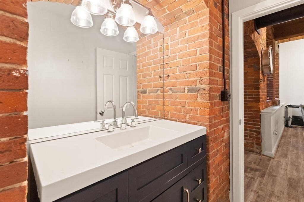 50 Rantoul Street, Unit 110 Beverly, MA 01915 - Photo 27 of 37 a bathroom with a sink a vanity and a mirror