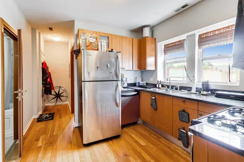 a kitchen with stainless steel appliances granite countertop a refrigerator and a sink