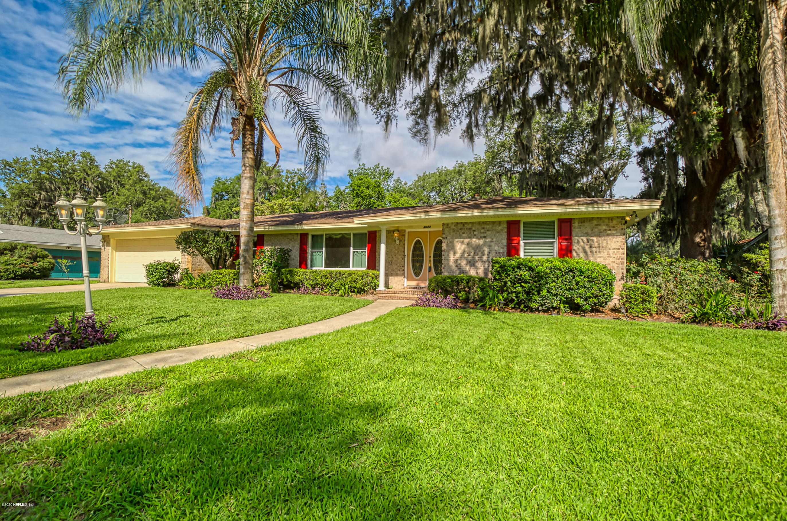 4024 Heath Road Jacksonville, FL 32277 - Photo 2 of 37 a front view of a house with a garden and palm trees