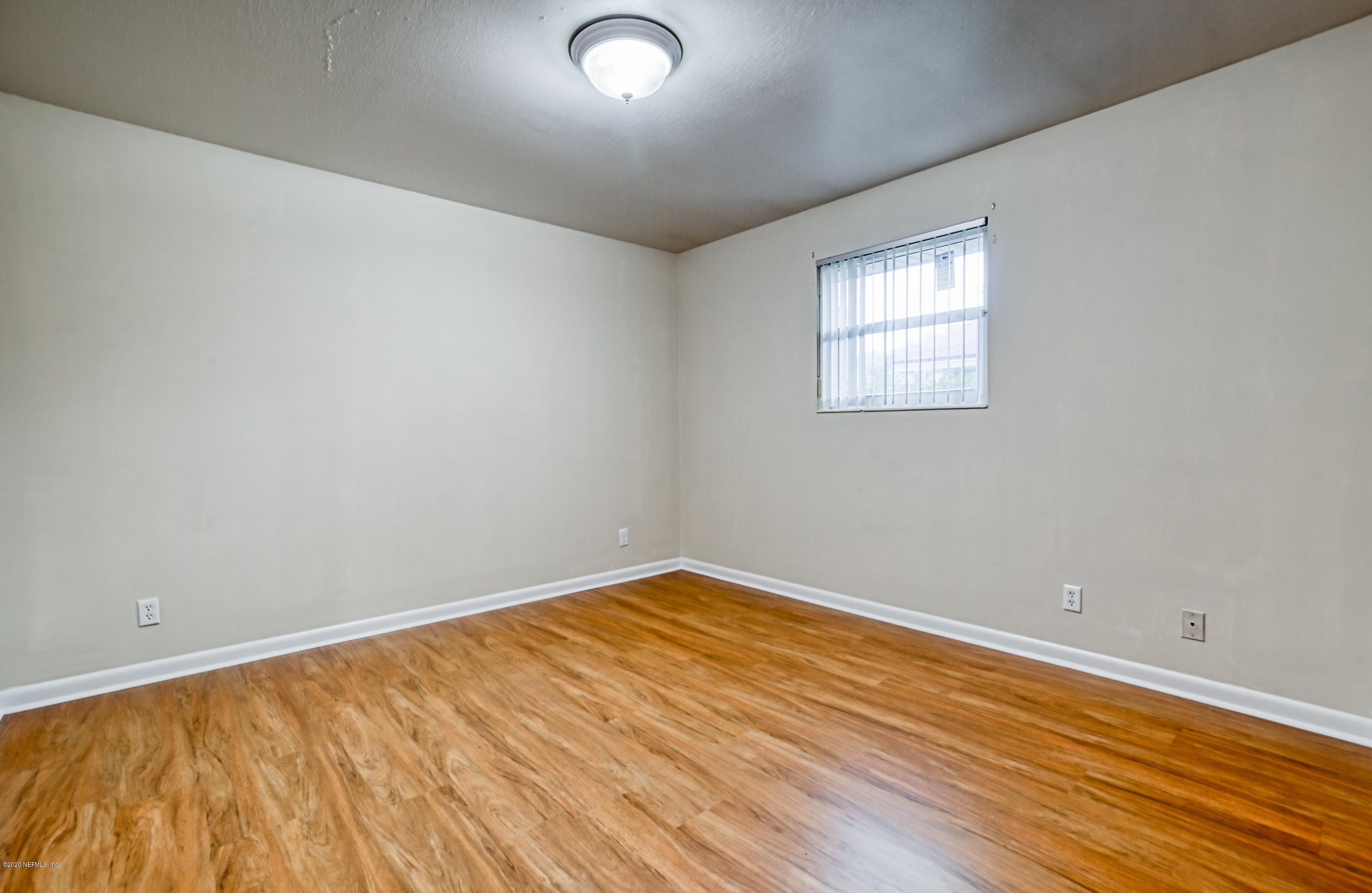 4024 Heath Road Jacksonville, FL 32277 - Photo 8 of 37 an empty room with wooden floor and windows