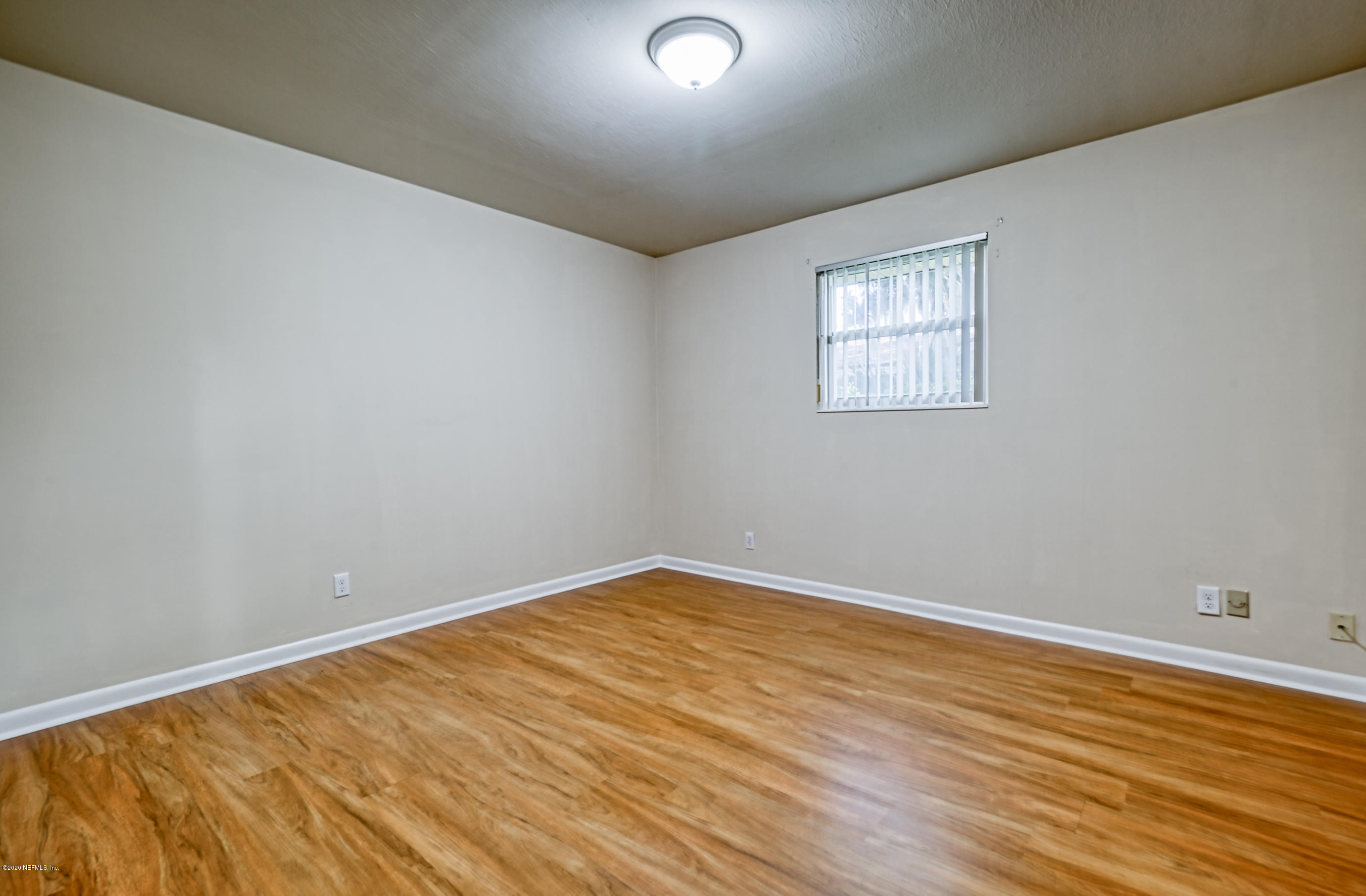 4024 Heath Road Jacksonville, FL 32277 - Photo 9 of 37 a view of an empty room with wooden floor and a window