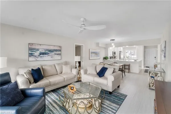 a living room with furniture kitchen view and a dining table