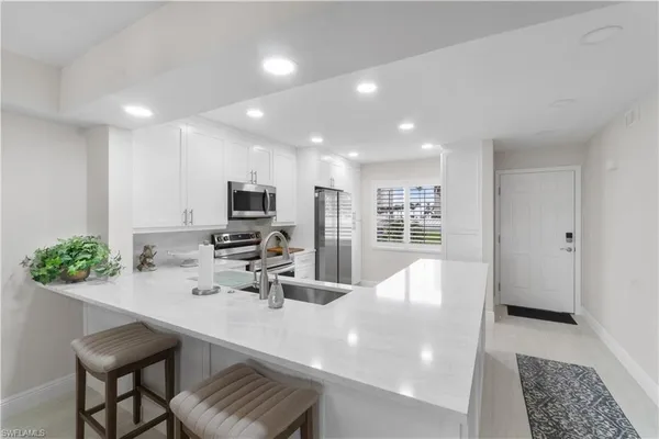 a kitchen with kitchen island a sink stainless steel appliances and cabinets