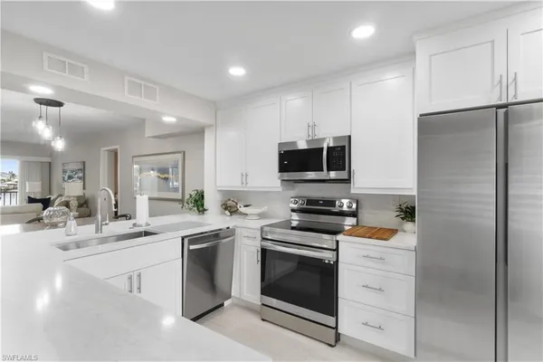 a kitchen with white cabinets and stainless steel appliances