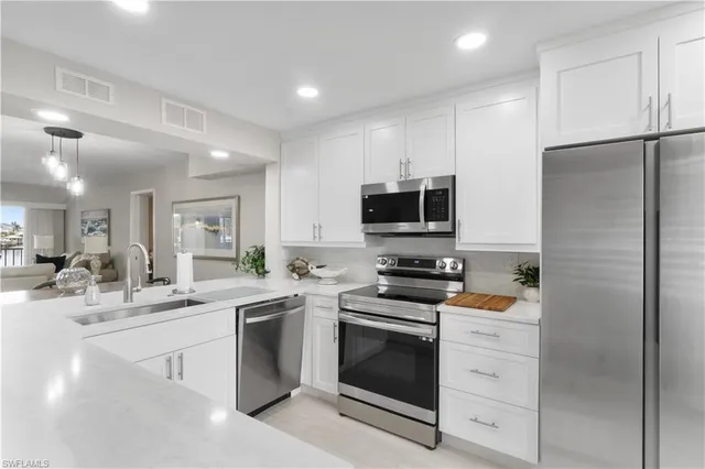 a kitchen with white cabinets and stainless steel appliances